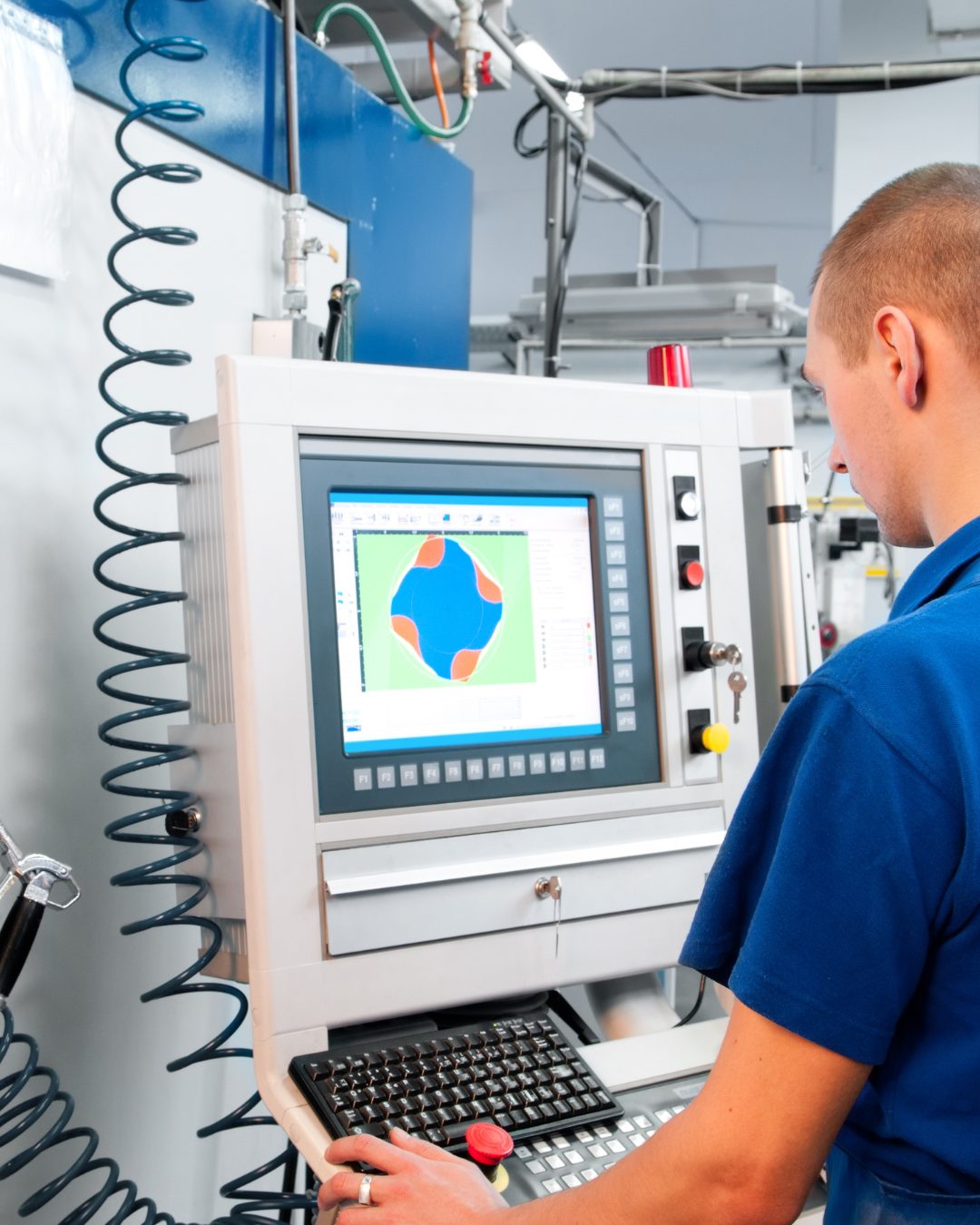 Maschinenbediener prüft ein Werkstück an der CNC-Steuerung