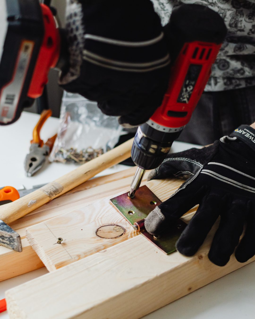 Handwerker verschraubt einen Metallwinkel auf Holz